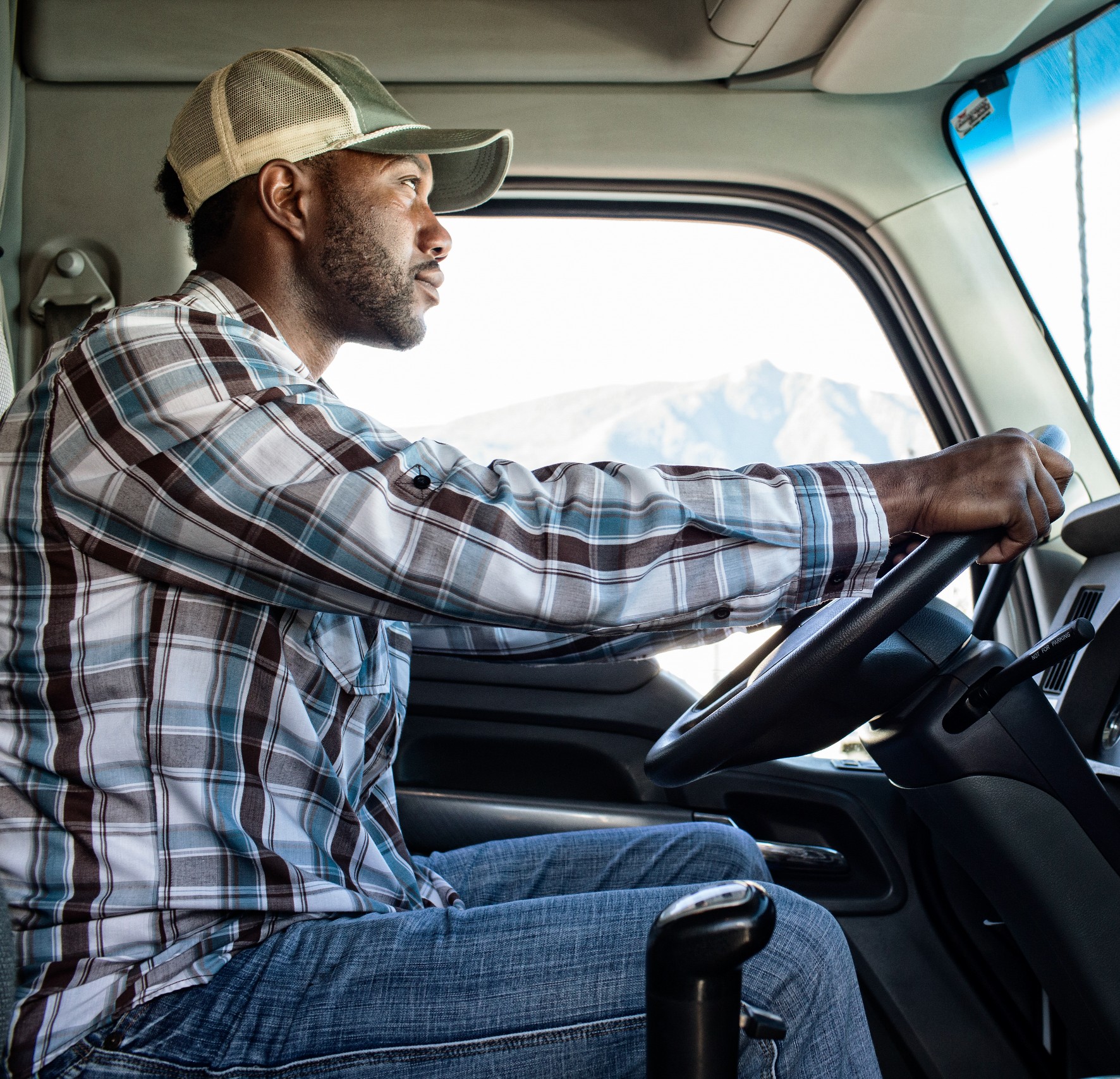 Black man truck driver in the cab of his commercial truck