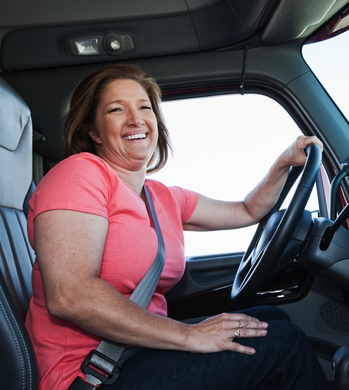 Caucasian woman driver in the cab of a commercial truck