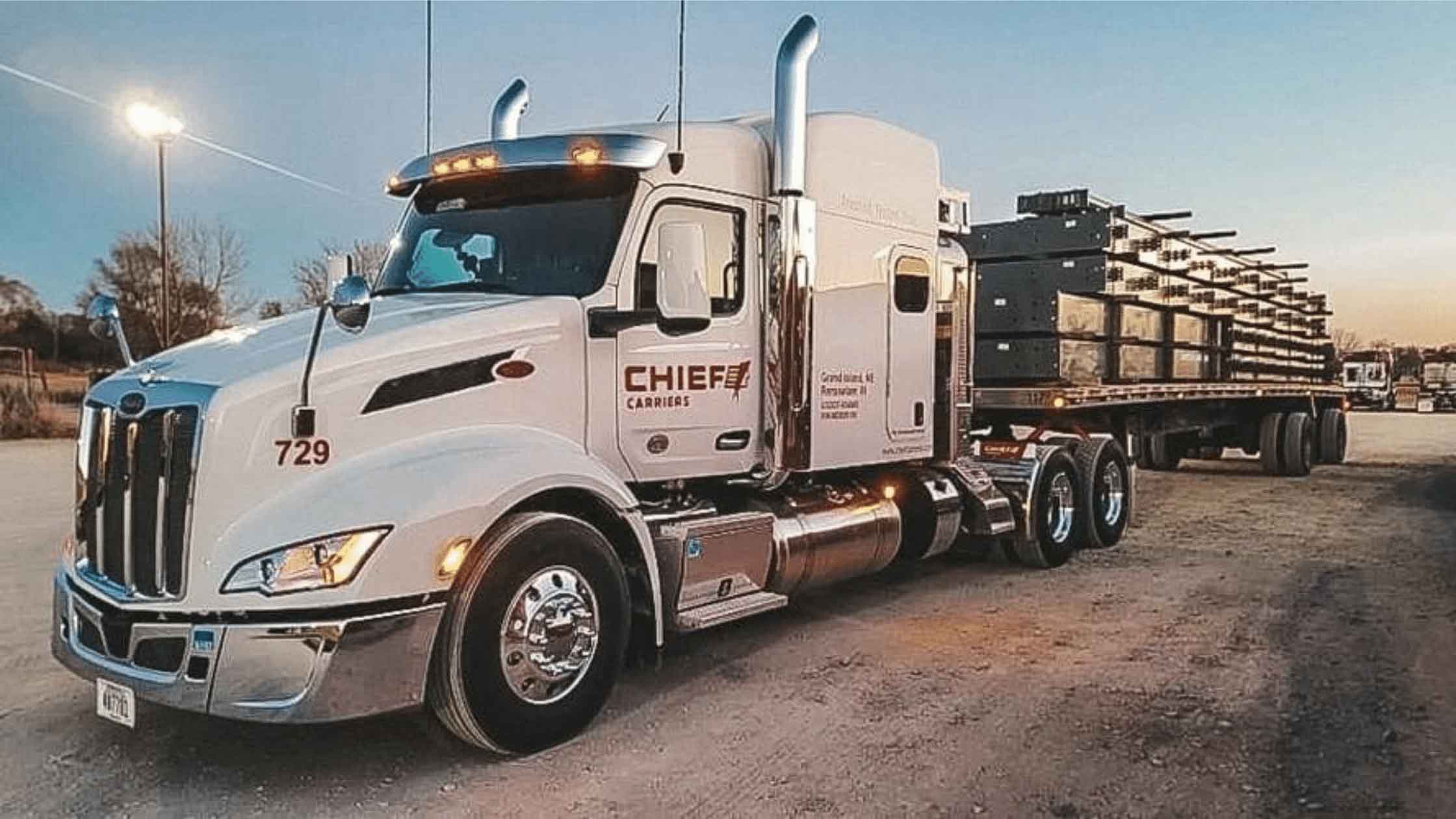 White chief carriers flatbed semi parked at dusk