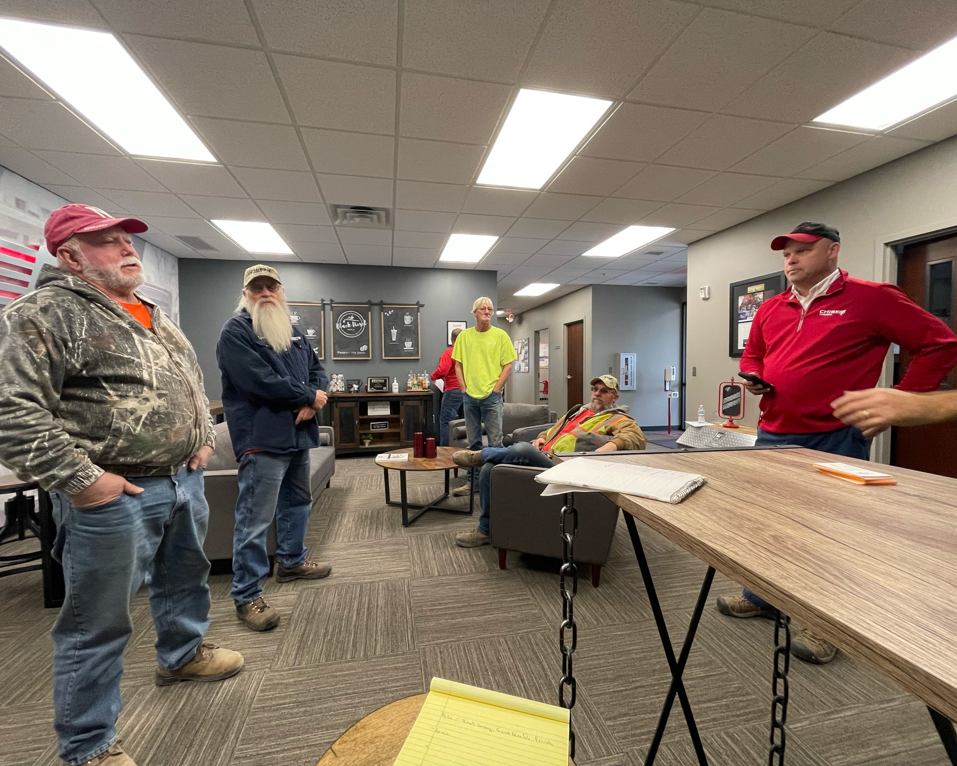 several truck drivers for chief carriers standing in their coffee room visiting