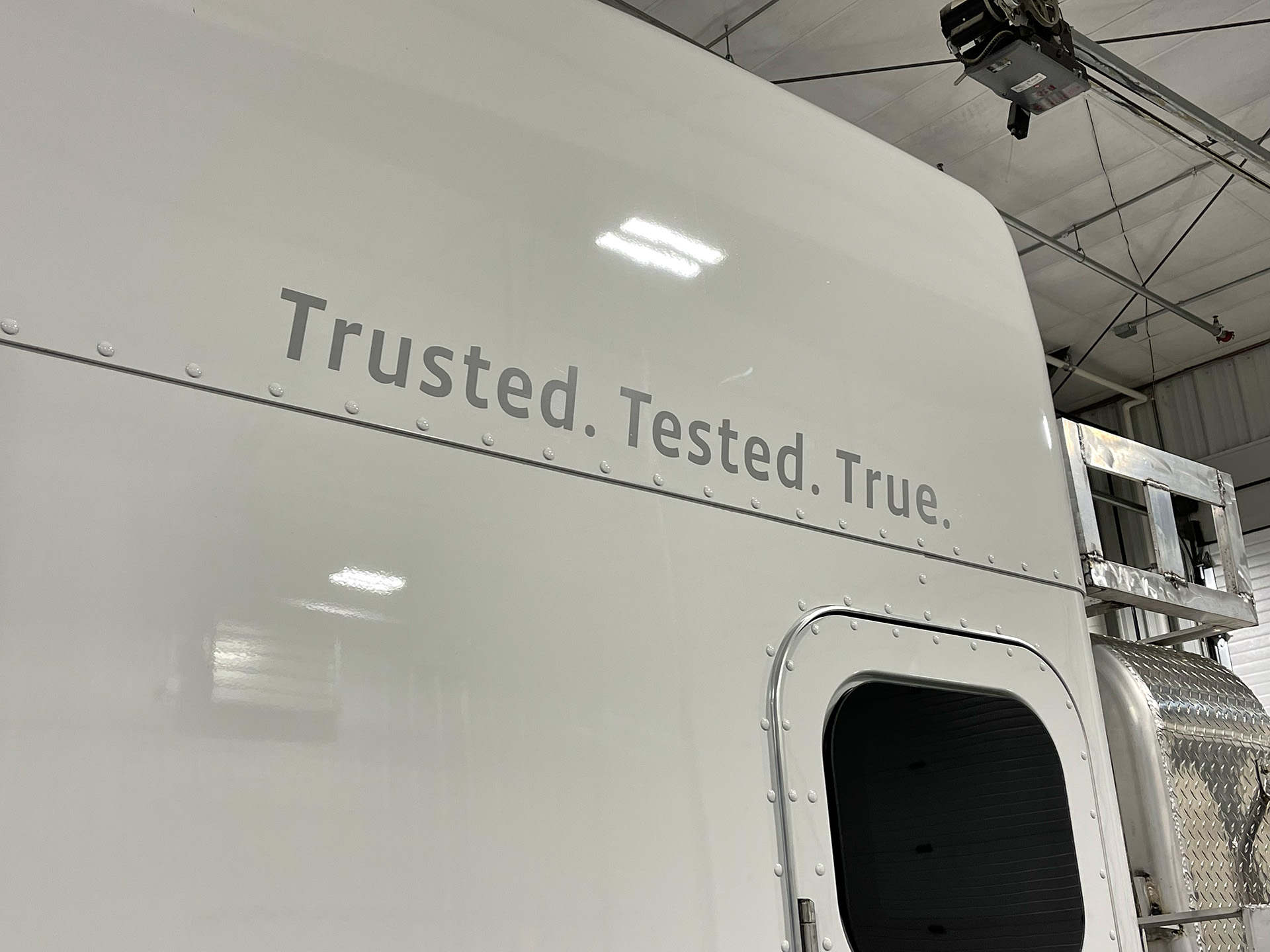 side of a chief carriers semi cab that says "trusted. tested. true."