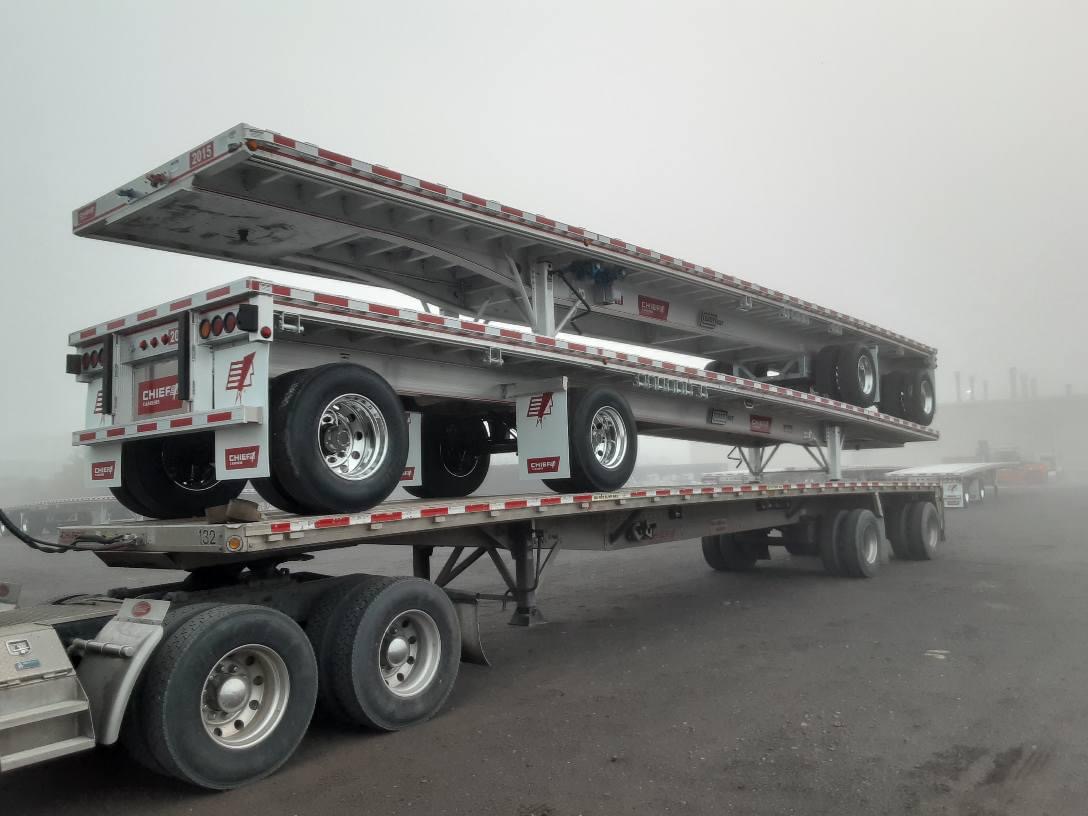 3 flatbed trailers stacked on top of each other in fog at Chief Carriers, who offers CDL jobs in Grand Island, NE