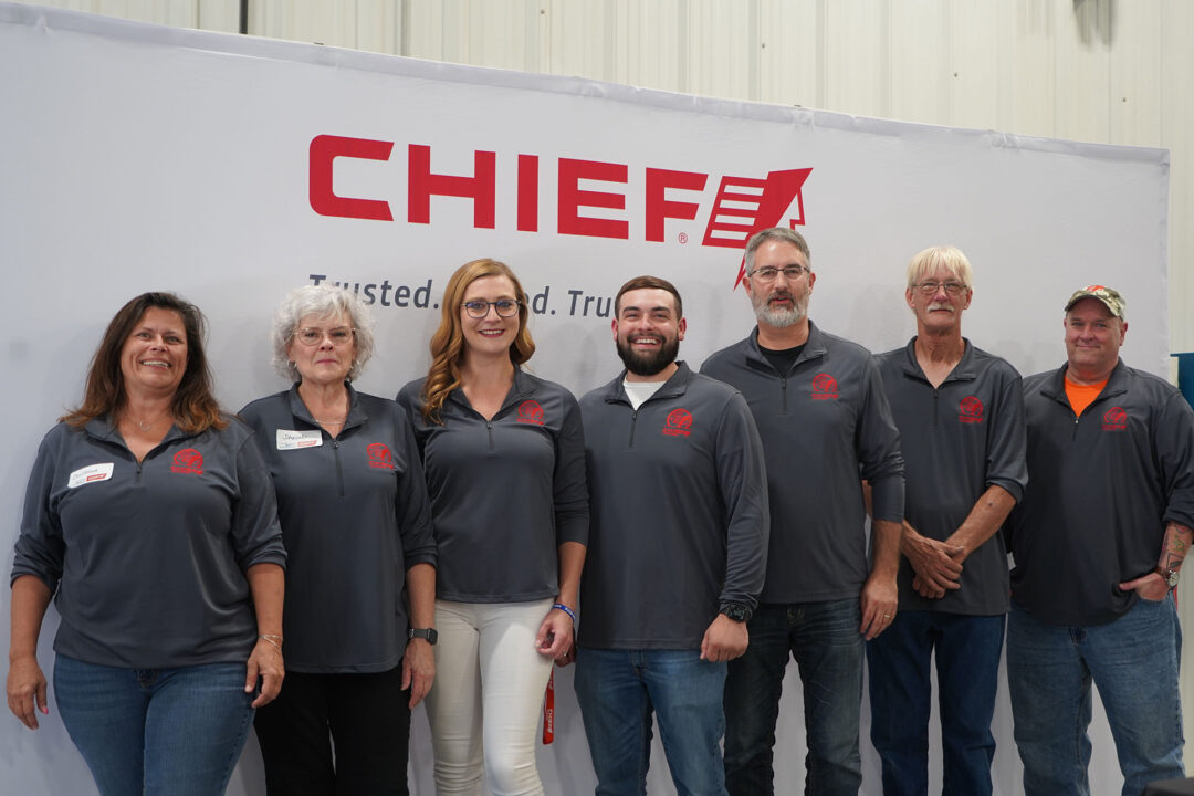 group of employees in front of the Chief sign at the 50th anniversary celebration