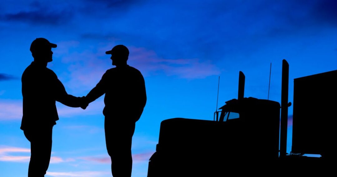 Truck driver shaking hands with man