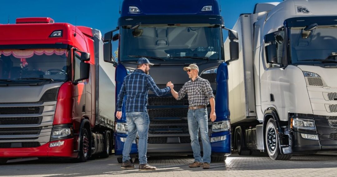 Two truck drivers shaking hands