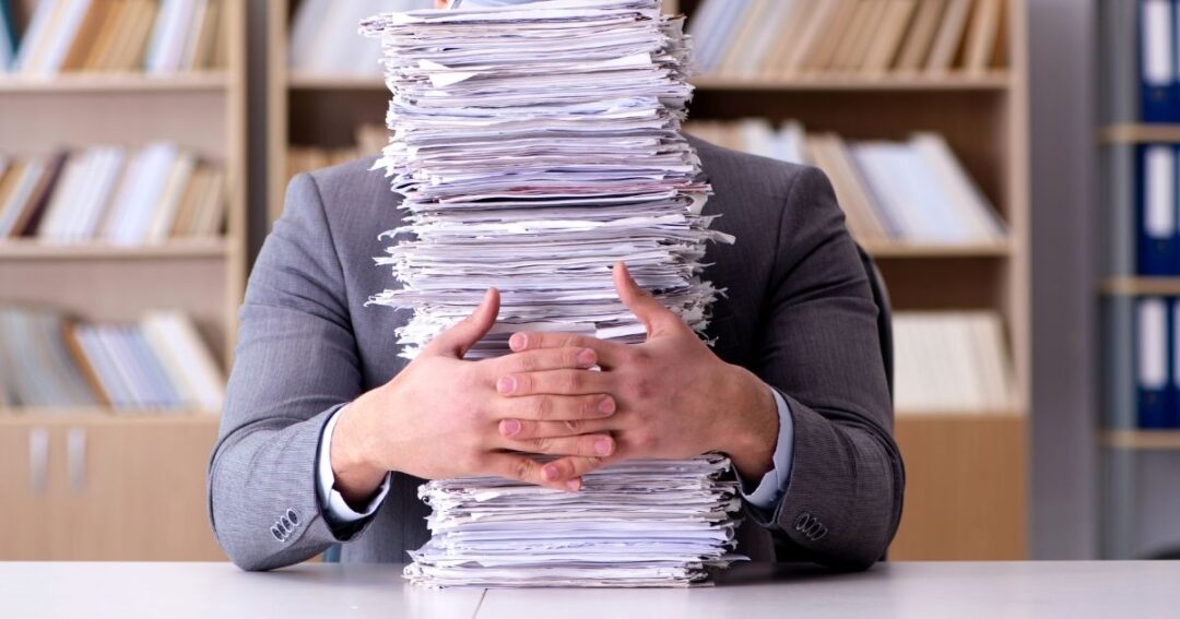 Person with a large stack of paperwork in front of them