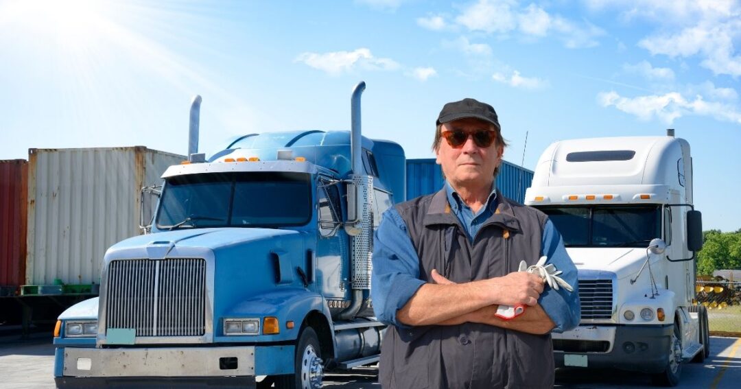 A truck driver standing in front of semi-trucks