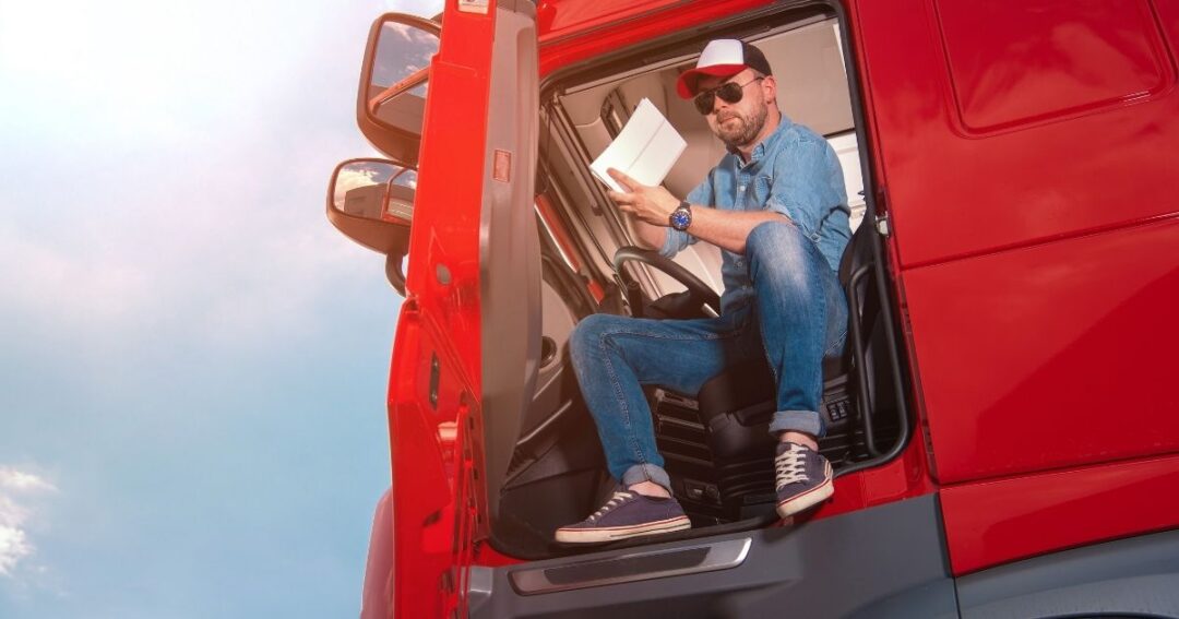 A truck driver in the cab of a semi-truck