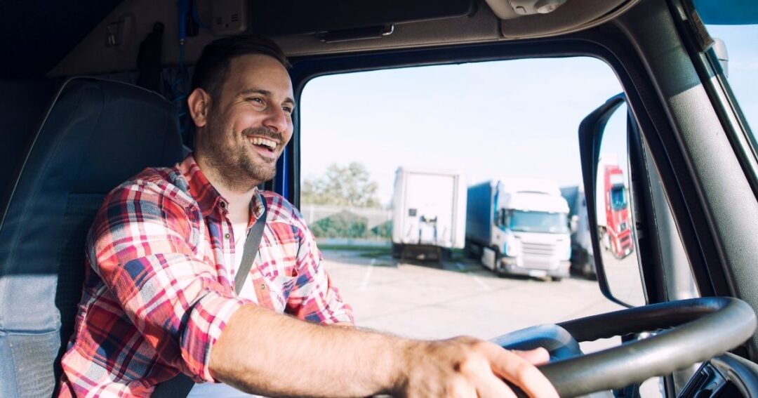 Smiling truck driver behind the wheel