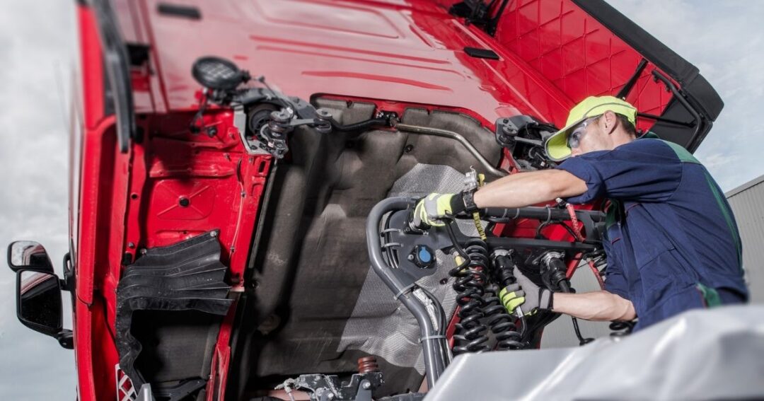 Man working on semi-truck engine