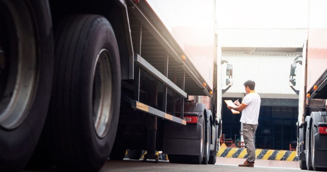 Man with clipboard inspecting semi-truck