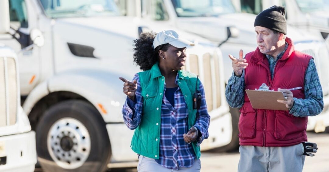Male and female trucking professionals having a conversation.