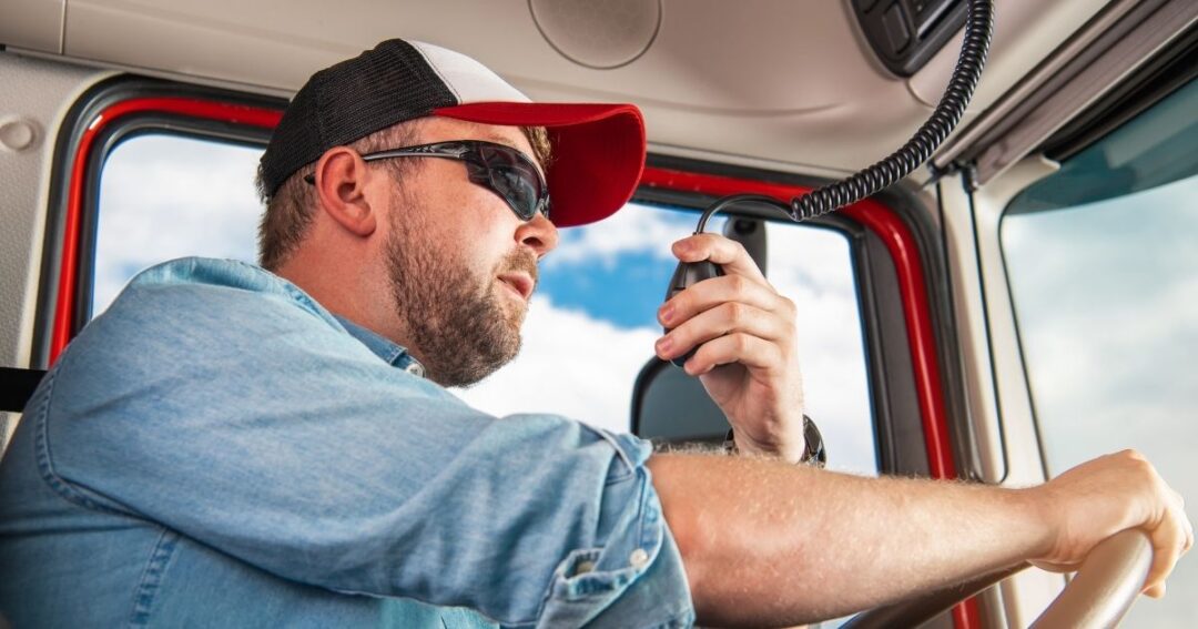A male truck driver on the truck's radio.