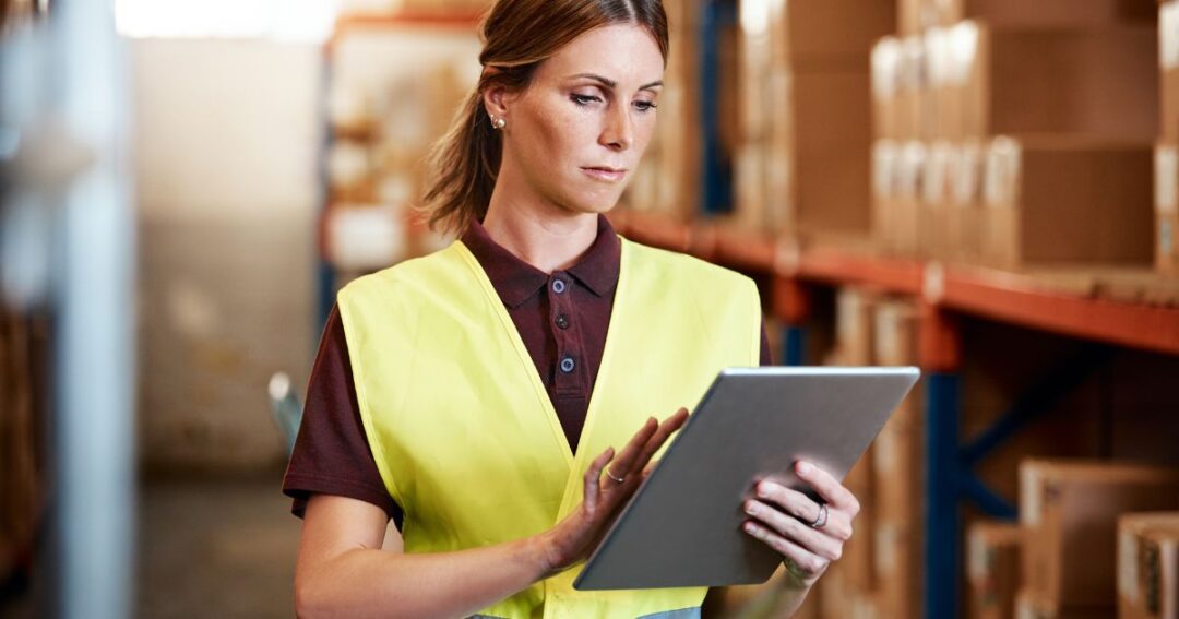 Woman checking inventory reports on a tablet.