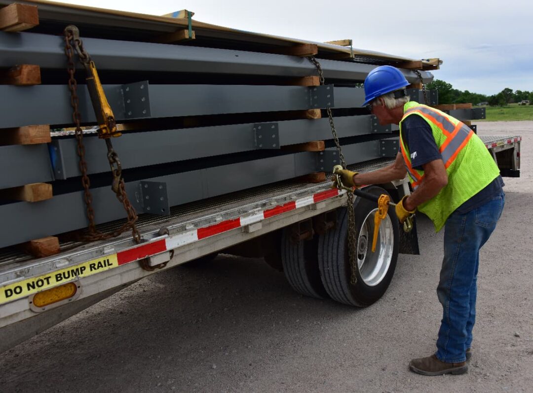 A Chief Carriers driver is securing chains for a flatbed load.