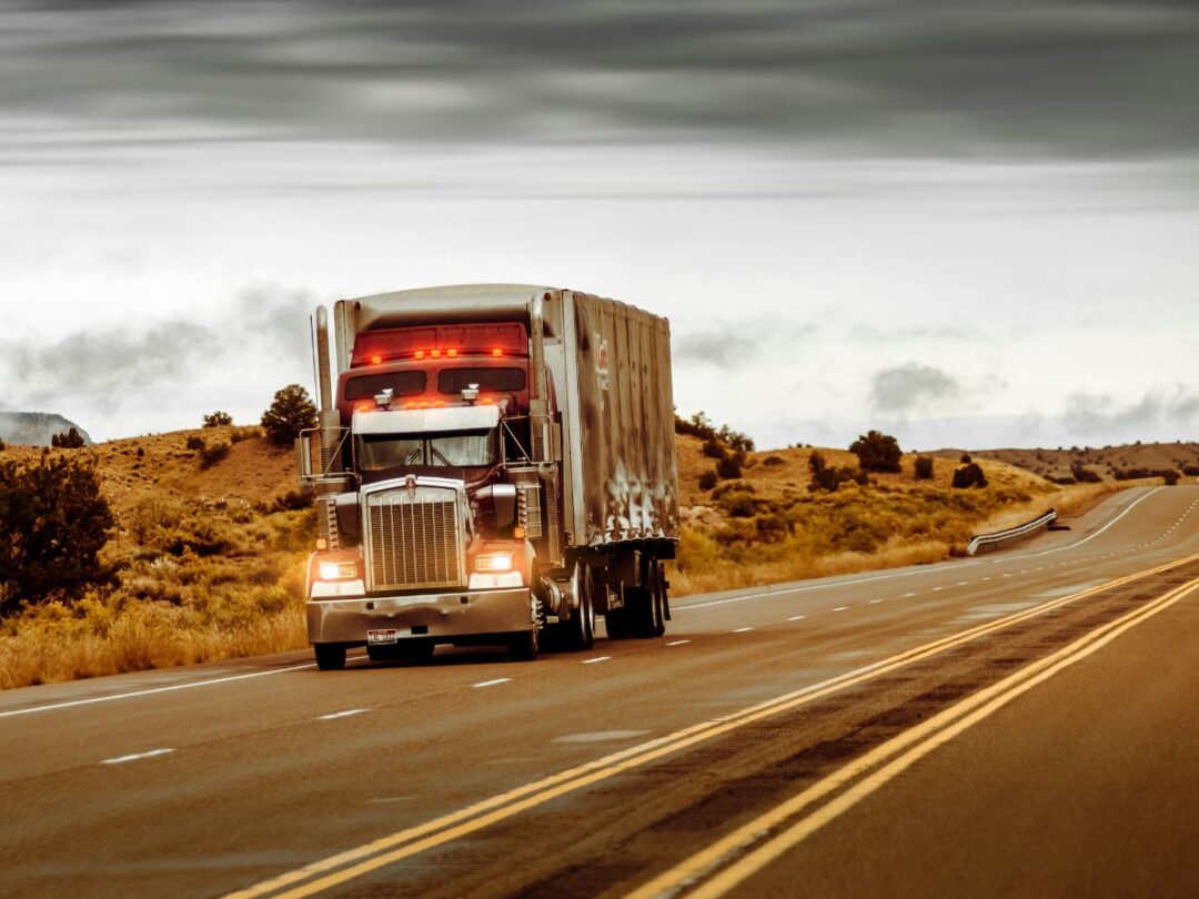 A commercial truck on a stretch of highway.