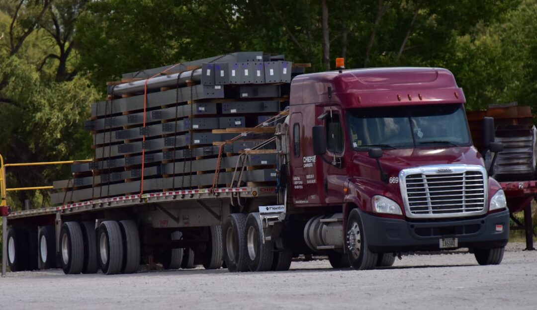 A well-secured load on a Chief Carriers flatbed truck.