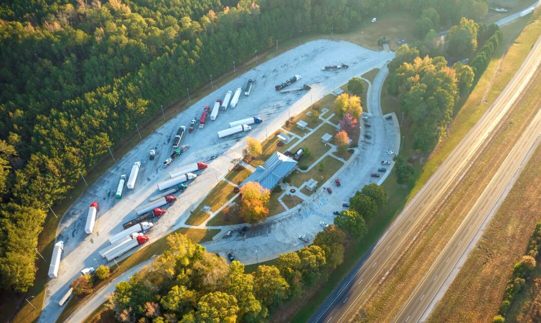 Aerial view of a truck stop rest area next to a highway.
