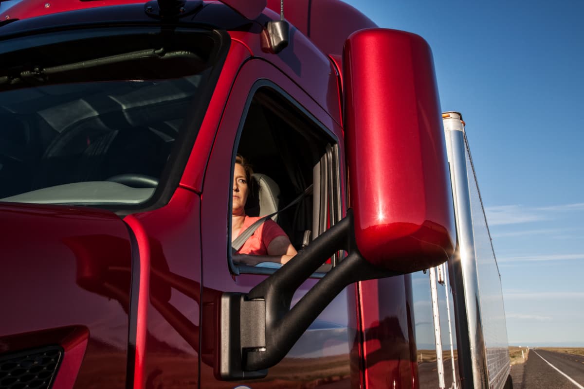 A woman truck driver looking concerned about finding safe truck parking.