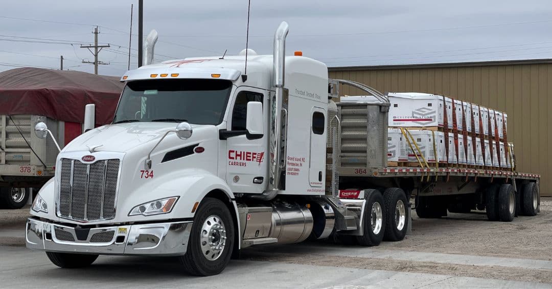 A loaded Chief Carriers flatbed truck.