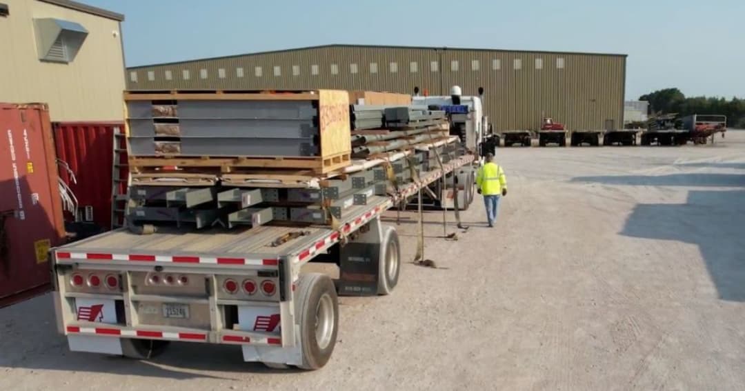A Chief Carriers flatbed load being secured before transport.