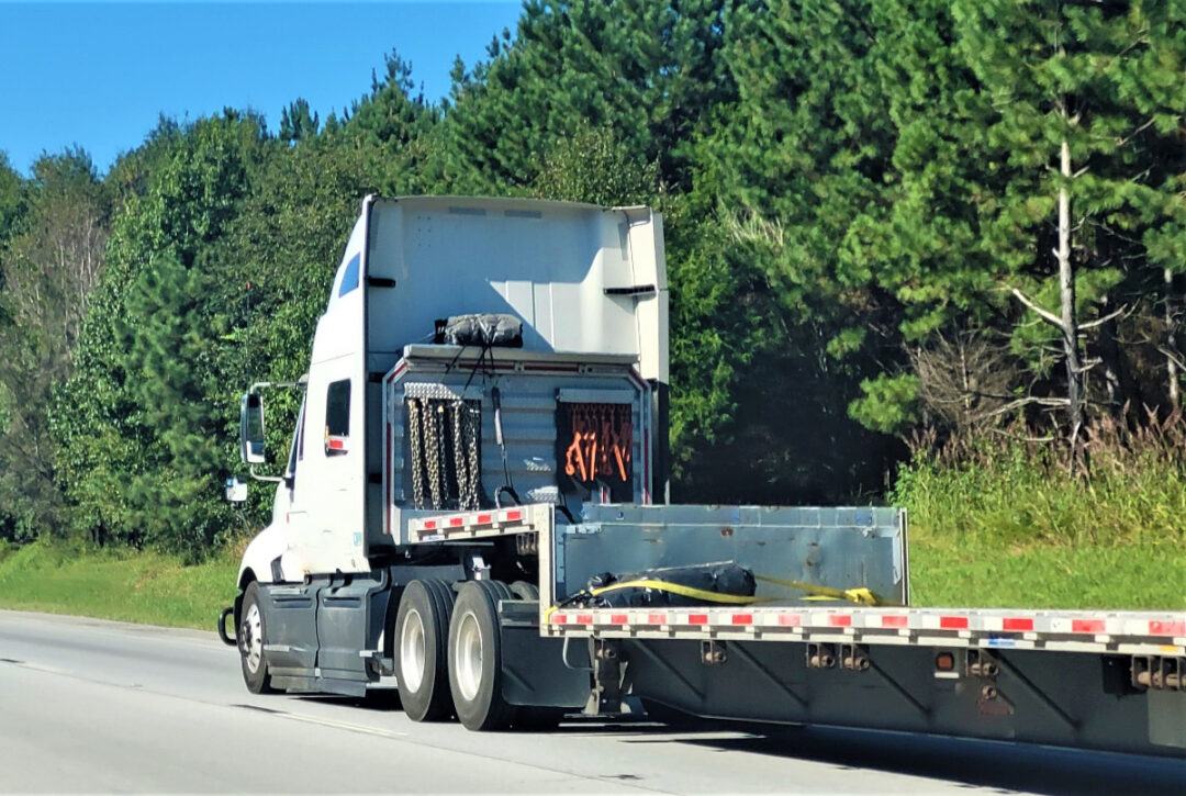 A low-boy flatbed trailer.