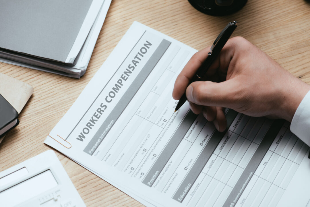 Unidentified man filling out workers compensation paperwork.