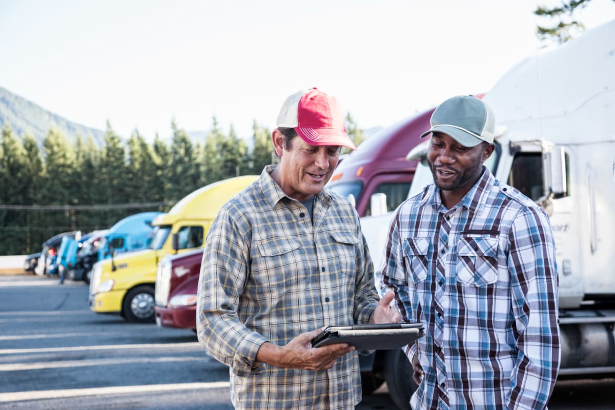 Two truck drivers going over paperwork together.