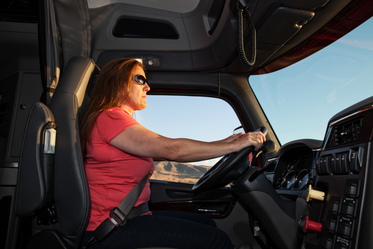 A woman truck driver behind the wheel.