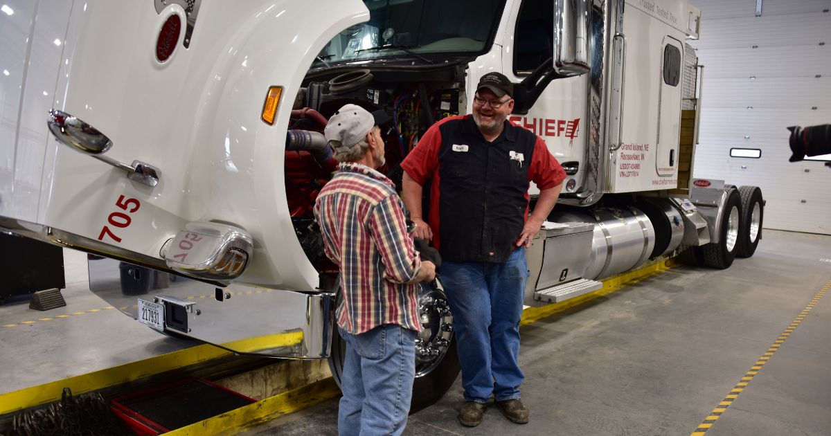 A Chief Carriers maintenance technician and a driver having a conversation in the maintenance shop.