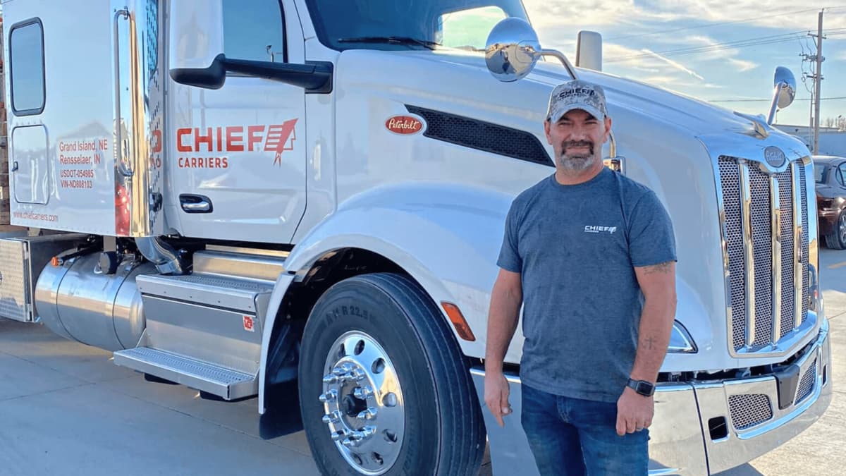A Chief Carriers driver standing next to a truck.