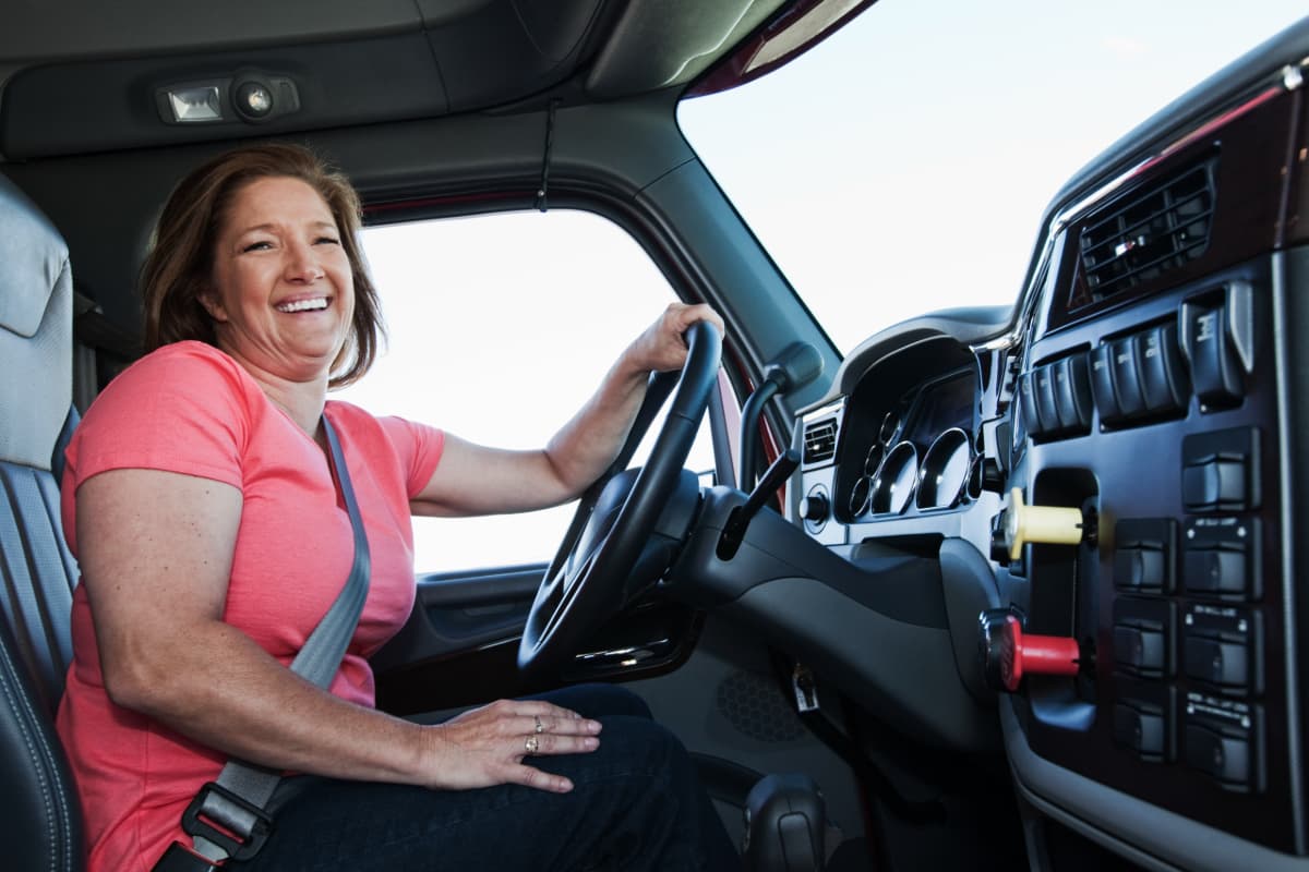 A smiling female truck driver.