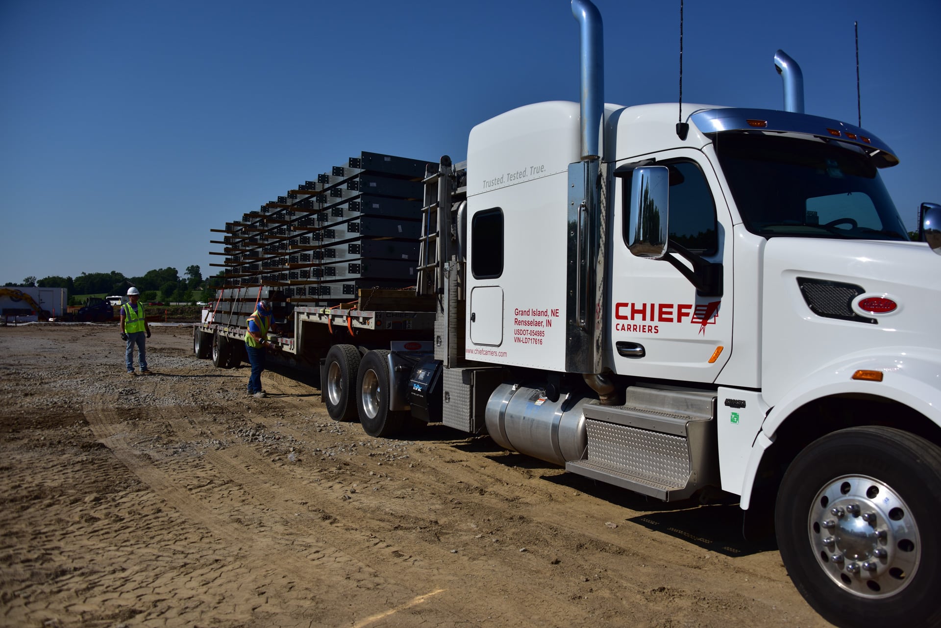 construction works stabilizing a load on a flatbed trailer driven by chief carriers in nebraska