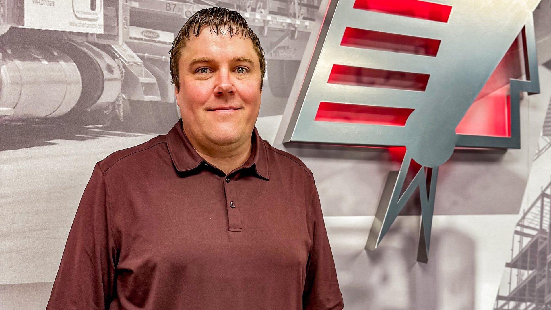 chief logistics manager dan adams staning in front of the chief logo