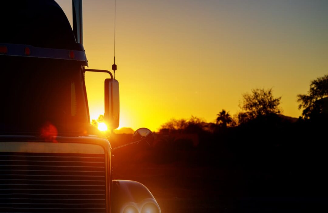A big rig truck at sunset.