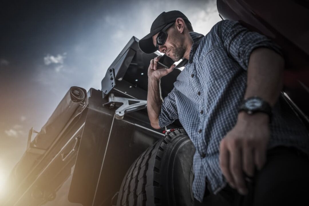 Law-angle view of a male trucker driver on his smartphone.
